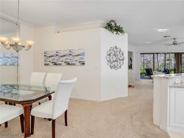 carpeted dining area featuring ornamental molding and ceiling fan with notable chandelier