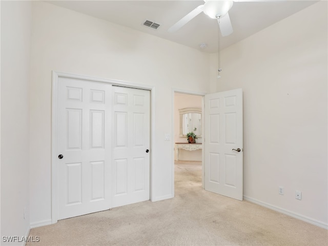 unfurnished bedroom with light carpet, a closet, and ceiling fan