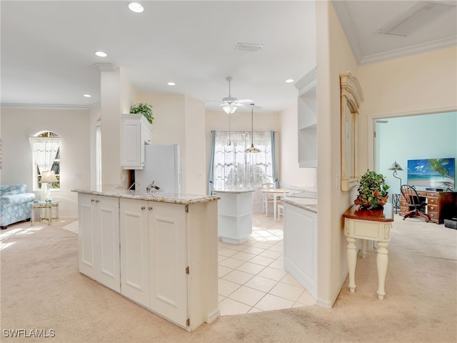 kitchen with a center island, light carpet, white cabinets, white fridge, and crown molding