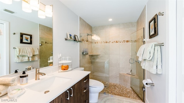 bathroom with toilet, vanity, tile patterned flooring, and walk in shower