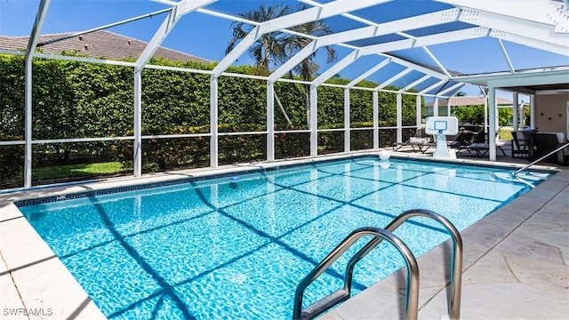 view of swimming pool featuring glass enclosure and a patio