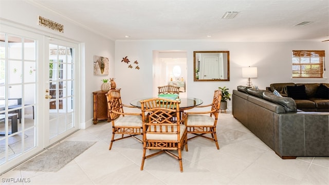 tiled dining space featuring crown molding and french doors