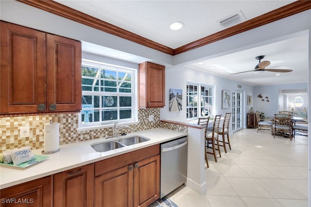 kitchen featuring tasteful backsplash, sink, ornamental molding, stainless steel dishwasher, and light tile patterned floors