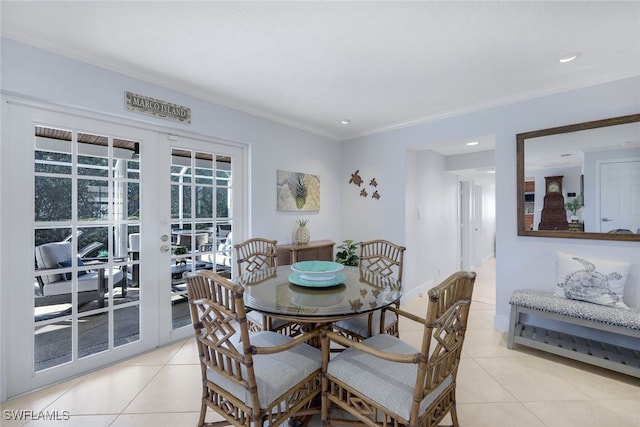 dining area with french doors, crown molding, and light tile patterned flooring