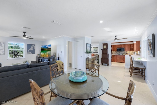 dining space featuring ornamental molding, ceiling fan, and light tile patterned flooring