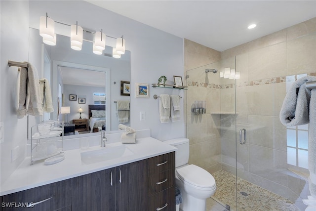 bathroom with vanity, toilet, and a shower with shower door