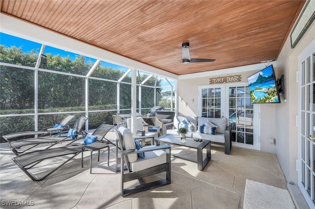 view of patio with a lanai, outdoor lounge area, french doors, and ceiling fan