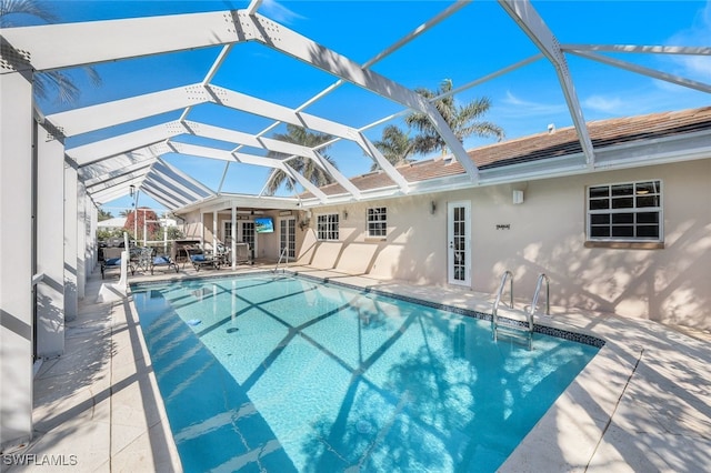 view of swimming pool featuring glass enclosure and a patio area