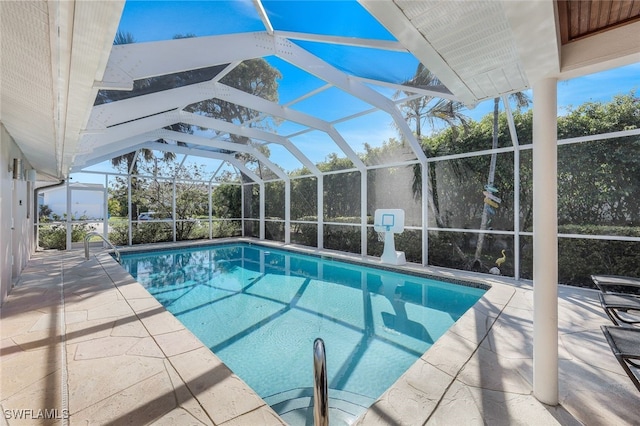 view of pool featuring glass enclosure and a patio area