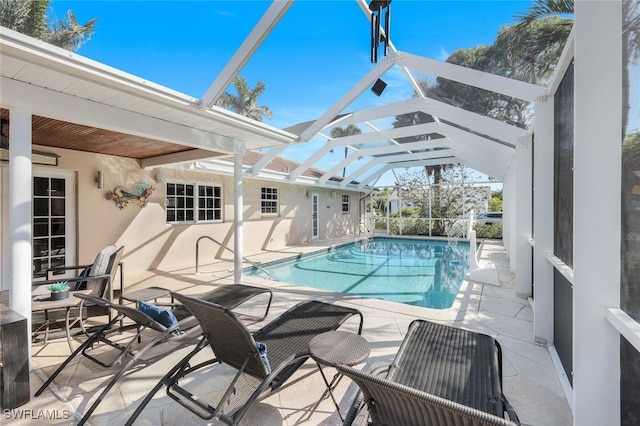 view of swimming pool featuring a patio and glass enclosure