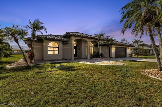 25373 Tether Ln, Punta Gorda, FL 33983 - mediterranean / spanish home with stucco siding, concrete driveway, a front lawn, and a garage