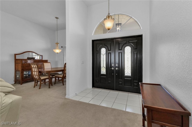 carpeted entryway with a towering ceiling