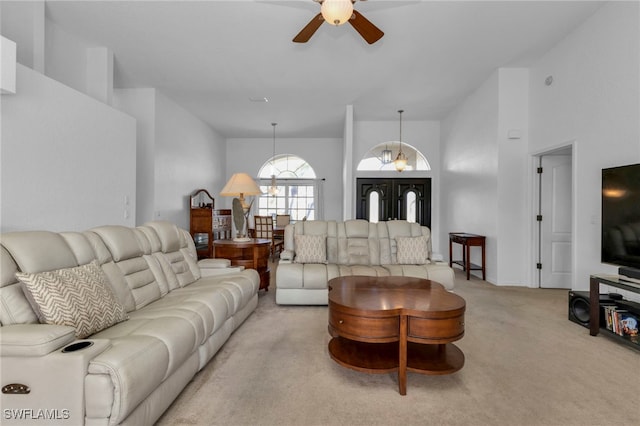 carpeted living room featuring ceiling fan with notable chandelier