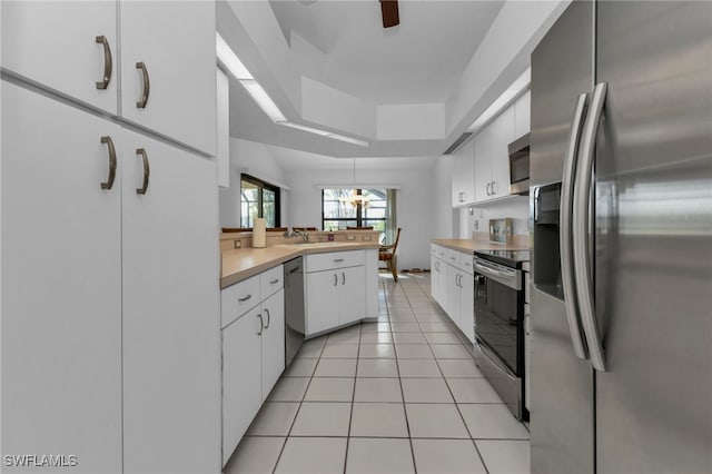 kitchen featuring white cabinets, kitchen peninsula, stainless steel appliances, and light tile patterned floors