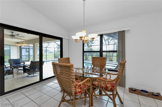 tiled dining room with ceiling fan with notable chandelier, a wealth of natural light, and lofted ceiling