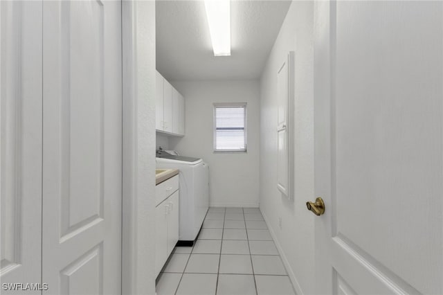 laundry area featuring separate washer and dryer, cabinets, and light tile patterned flooring