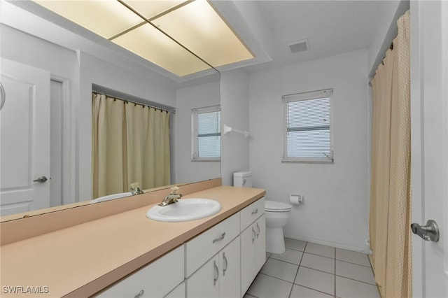 bathroom with toilet, vanity, and tile patterned floors