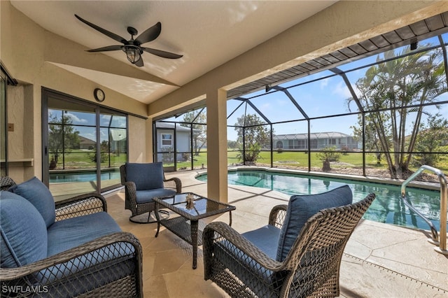 view of pool featuring glass enclosure, ceiling fan, a patio, and an outdoor living space