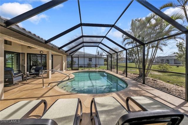 view of pool with glass enclosure and a patio area