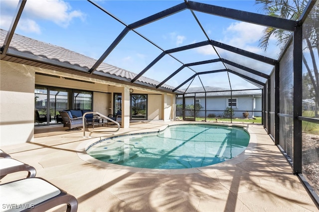 view of pool featuring outdoor lounge area, glass enclosure, and a patio area