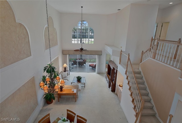 interior space featuring ceiling fan and a high ceiling