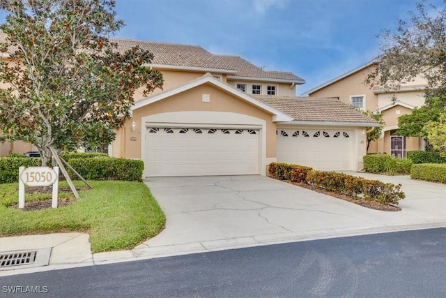 view of front of property with a tile roof, concrete driveway, a garage, and stucco siding