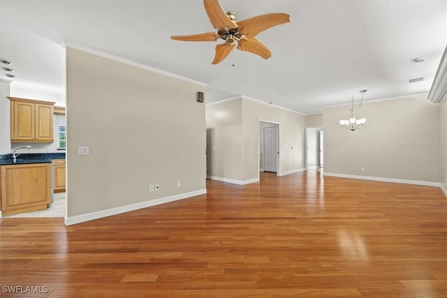 unfurnished living room with crown molding, ceiling fan with notable chandelier, and light wood-type flooring