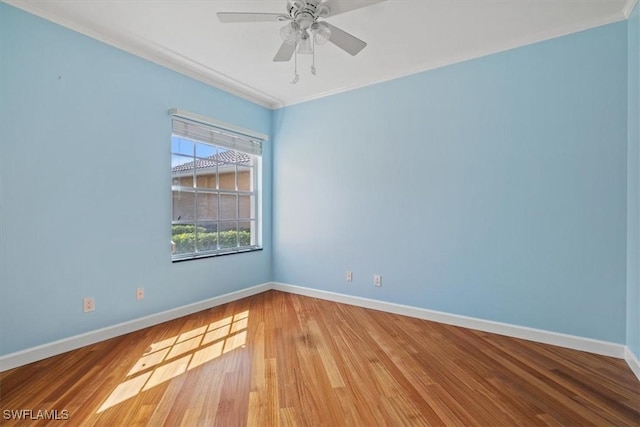 unfurnished room featuring a ceiling fan, wood finished floors, baseboards, and ornamental molding