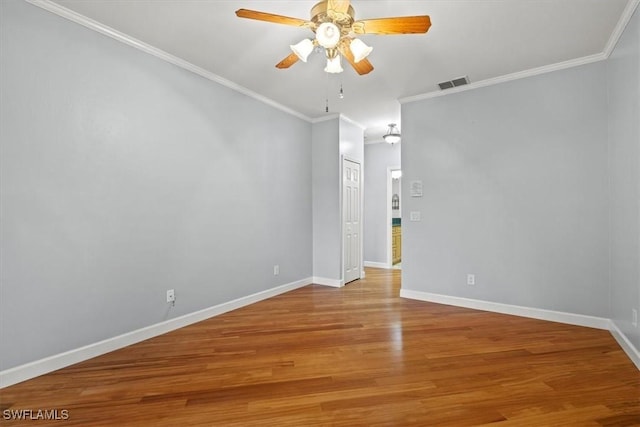 spare room with visible vents, ceiling fan, baseboards, ornamental molding, and wood finished floors