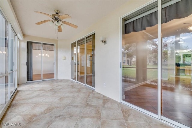 unfurnished sunroom with a wealth of natural light and ceiling fan