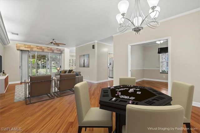 dining space with visible vents, ceiling fan with notable chandelier, crown molding, and light wood-style floors