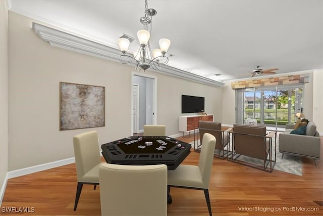 dining space with light wood-style flooring, ceiling fan with notable chandelier, and baseboards