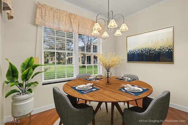 dining room featuring ornamental molding, hardwood / wood-style floors, and a notable chandelier