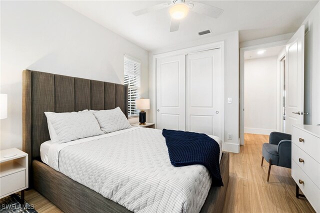 bedroom with light hardwood / wood-style floors, ceiling fan, and a closet