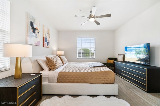 bedroom with light hardwood / wood-style floors and ceiling fan