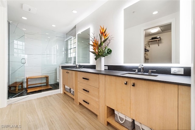 bathroom with an enclosed shower, vanity, and hardwood / wood-style floors