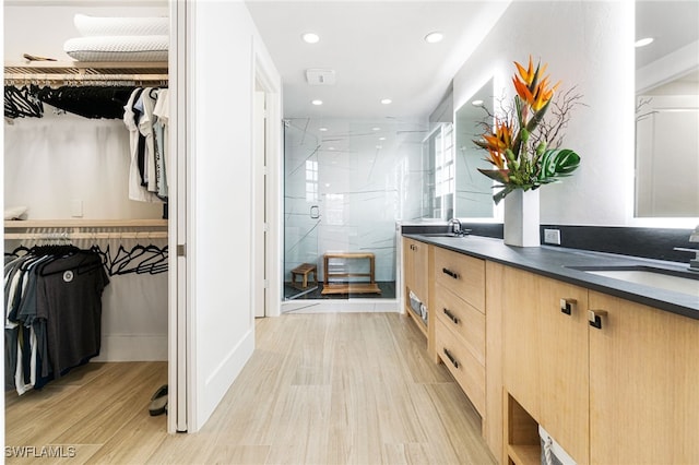 bathroom featuring walk in shower, hardwood / wood-style floors, and vanity