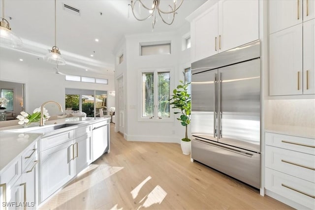 kitchen featuring white cabinetry, stainless steel built in refrigerator, and light wood-type flooring