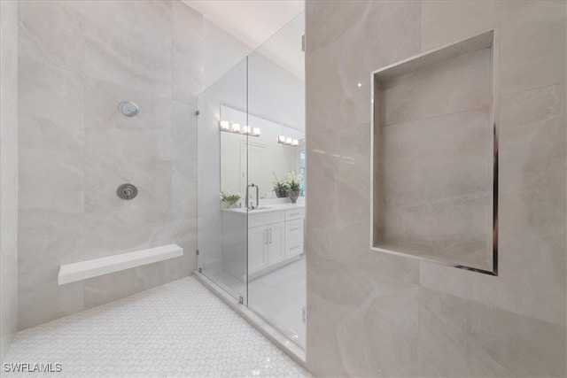 bathroom with vanity, walk in shower, and tile walls