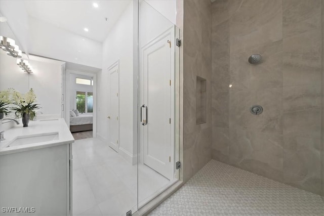 bathroom with tiled shower, vanity, and tile patterned floors