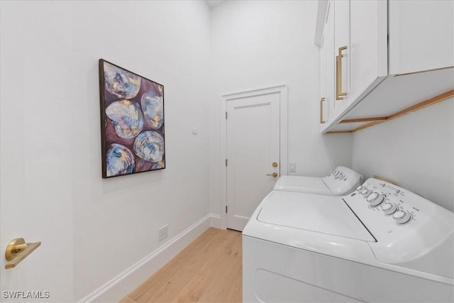 washroom with washer and clothes dryer, cabinets, and light hardwood / wood-style floors