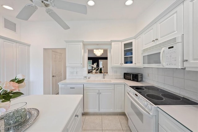 kitchen featuring backsplash, sink, white appliances, light tile patterned flooring, and white cabinets