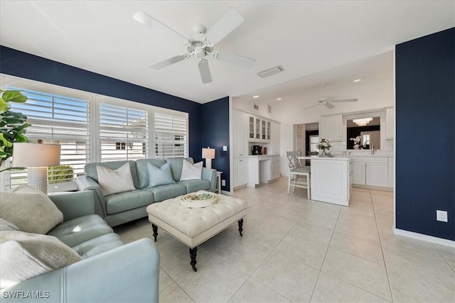 living room with ceiling fan, light tile patterned floors, and sink