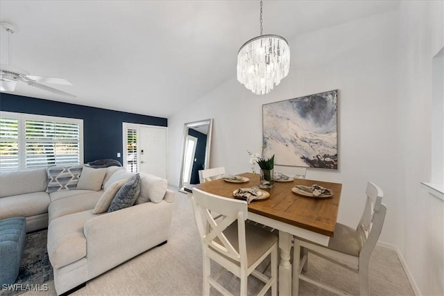 carpeted dining space with lofted ceiling and ceiling fan with notable chandelier