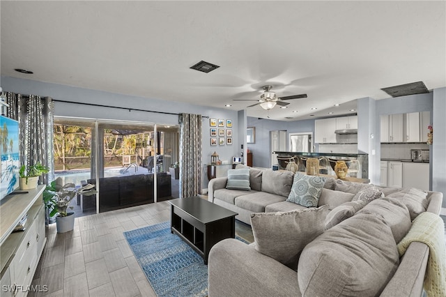 living room with ceiling fan and light hardwood / wood-style floors