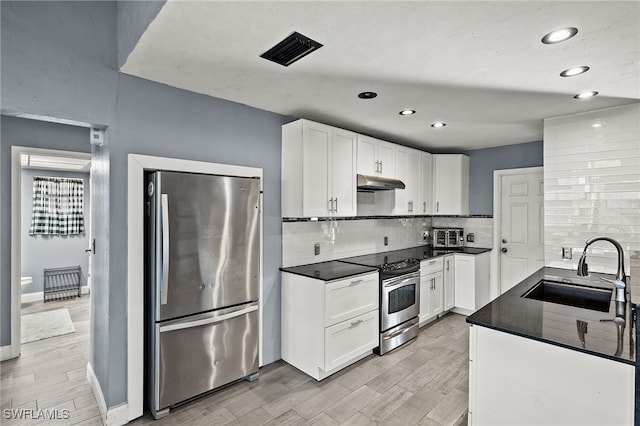 kitchen featuring appliances with stainless steel finishes, white cabinets, sink, and light hardwood / wood-style floors