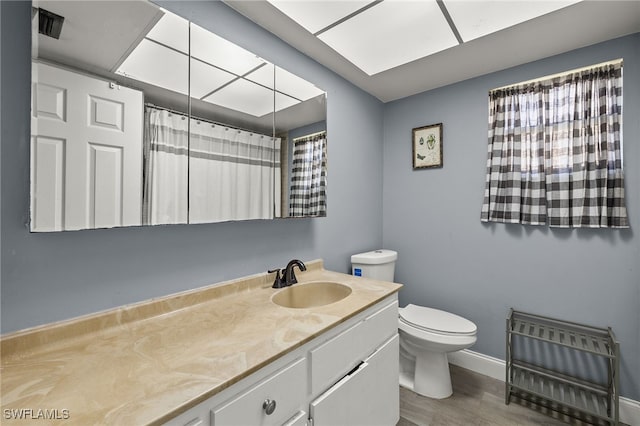 bathroom with toilet, hardwood / wood-style floors, vanity, and heating unit