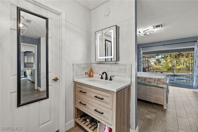 bathroom featuring vanity, wood-type flooring, and backsplash