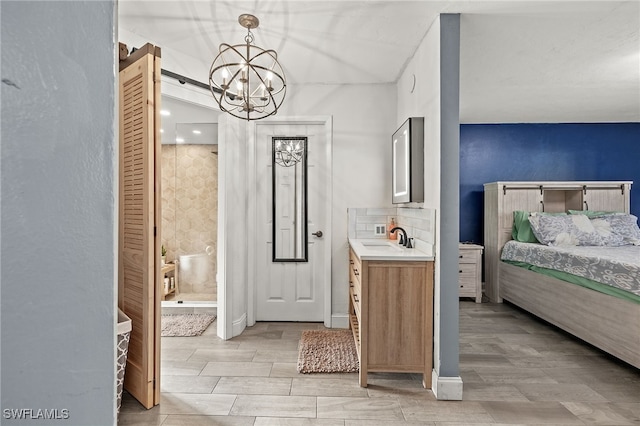 bathroom with vanity, tasteful backsplash, a chandelier, and hardwood / wood-style floors