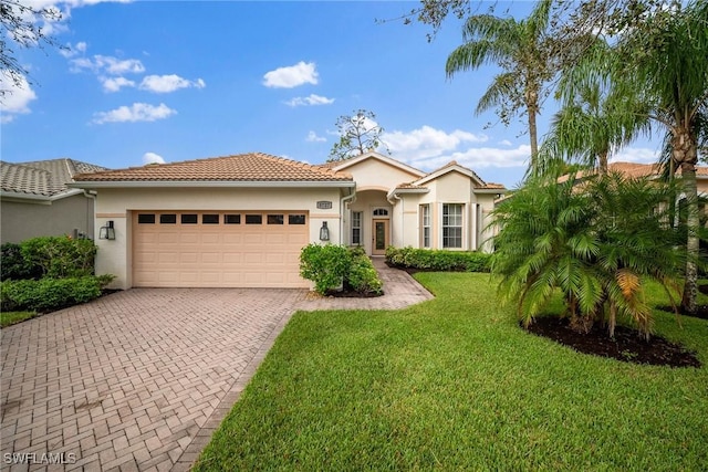 mediterranean / spanish-style house with a garage and a front lawn